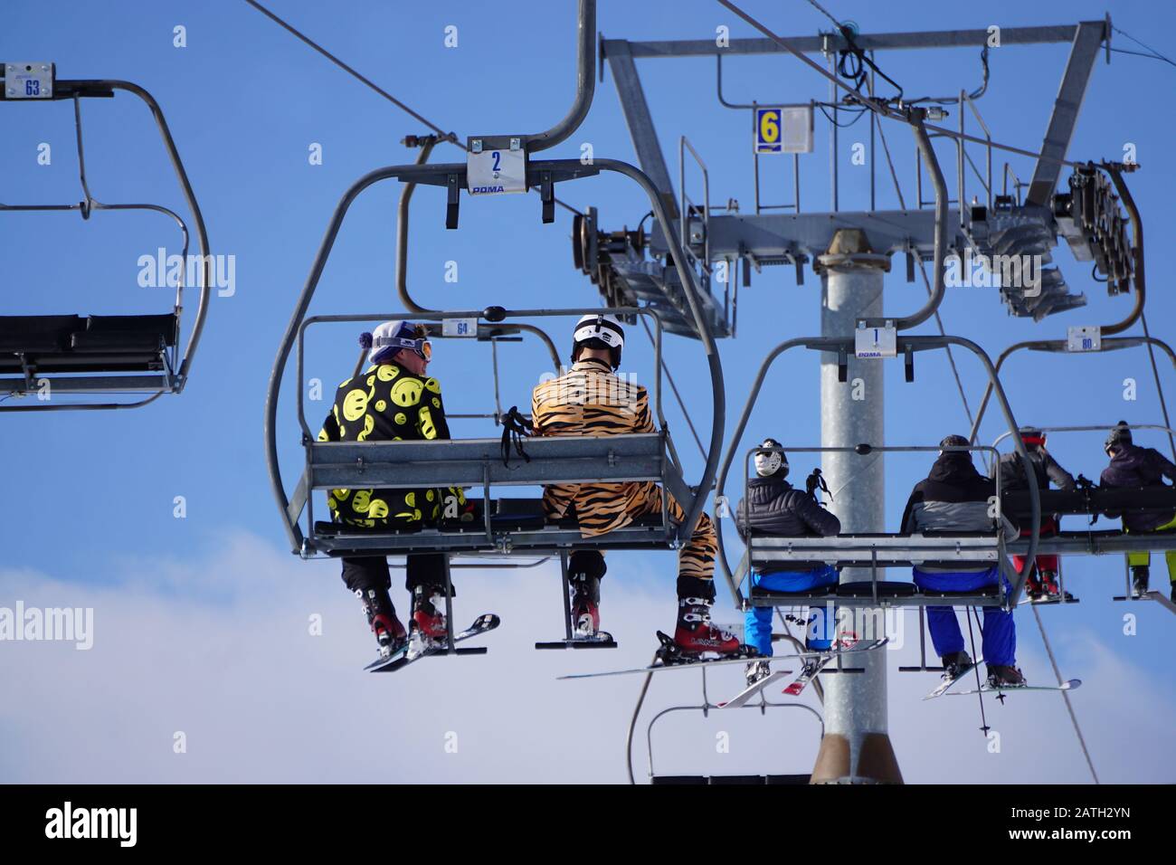 Vue sur les gars portant une tenue amusante pour skier sur le télésiège dans une station de ski française dans les Alpes Banque D'Images