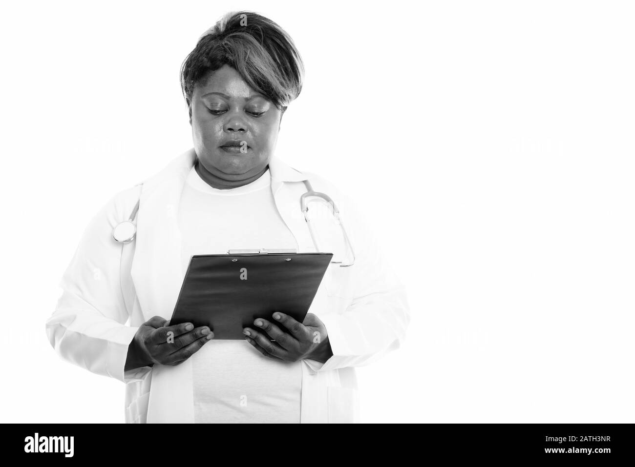 Studio tourné de graisse noire africaine femme médecin regardant le presse-papiers Banque D'Images