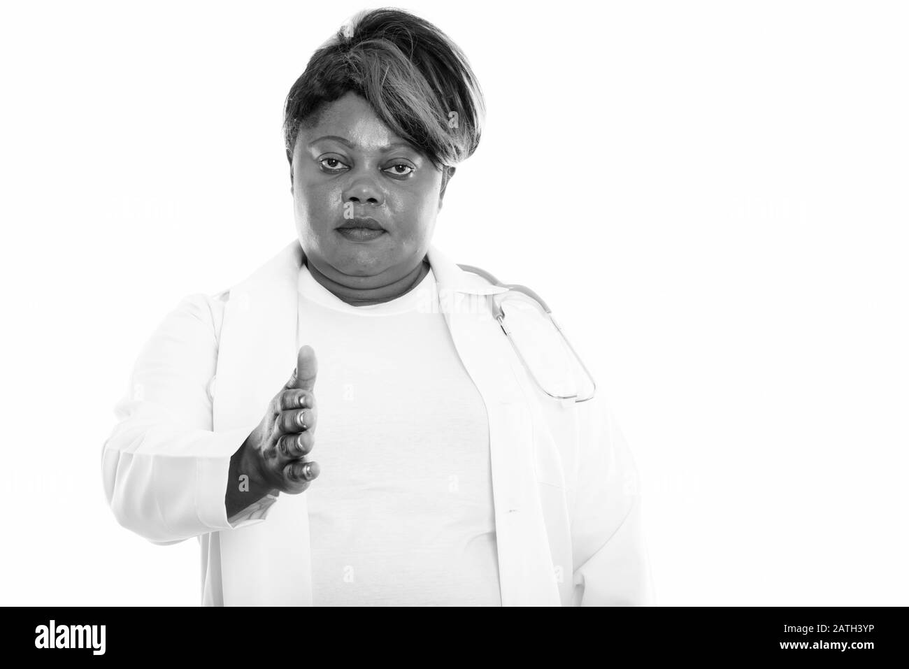 Studio shot of fat black African woman doctor giving handshake Banque D'Images