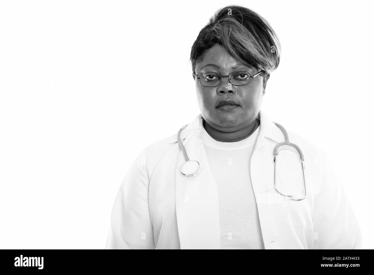 Studio shot of fat black African woman doctor wearing eyeglasses Banque D'Images