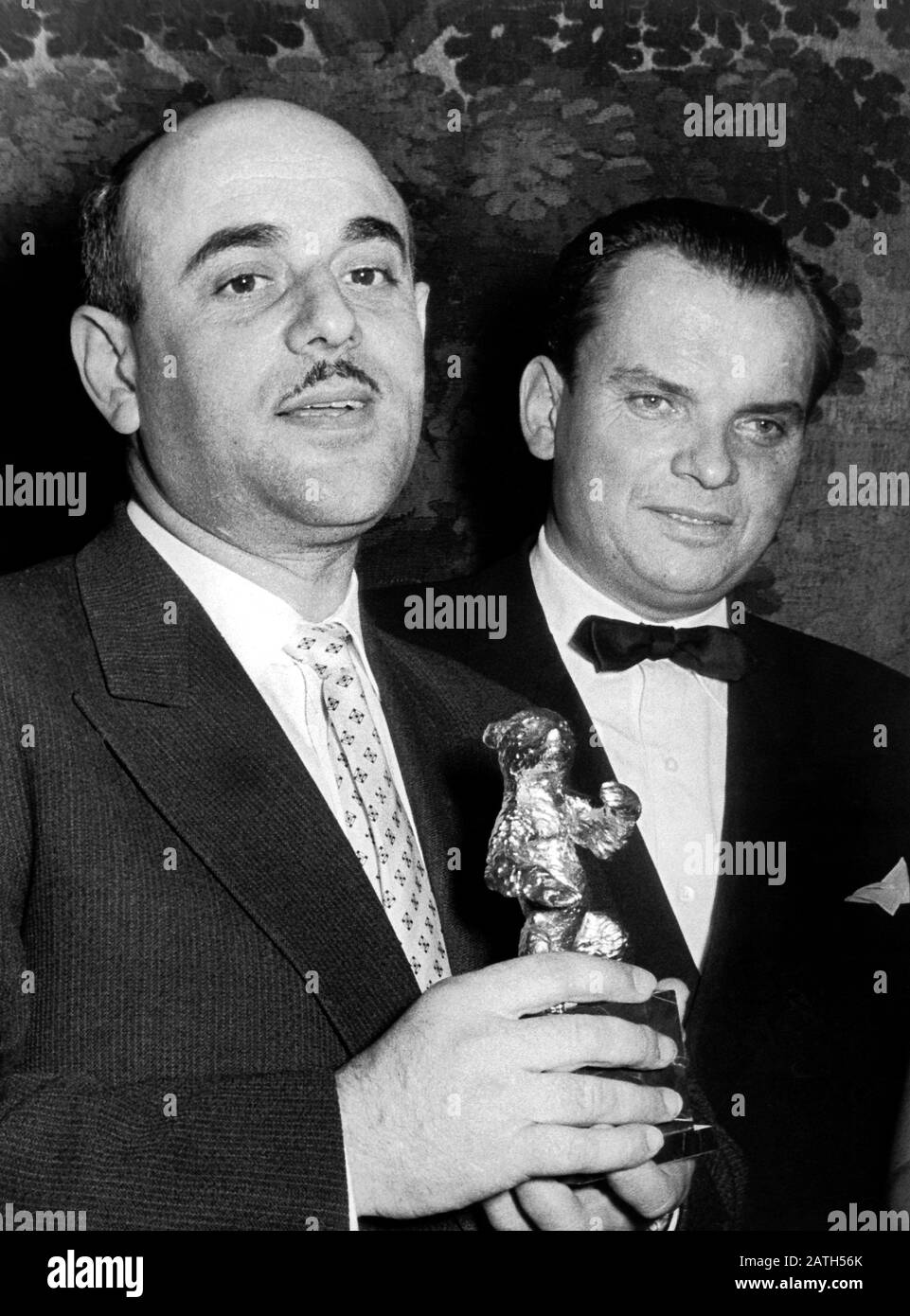 Artur Brauner (l) a été honoré au 6ème Festival International du Film à Berlin en juillet 1956 pour le film "Avant coucher du soleil", produit par sa société CCC-Film GmbH, avec l'Ours d'or du vote public, aux côtés de son patron Berlinale Alfred Bauer. Le producteur de films Brauner célèbre son 85ème anniversaire le 1 août. Brauner est né à Lodz, en Pologne, à un grossiste juif et a survécu à l'holocauste et à la seconde Guerre mondiale Il a façonné le film allemand d'après-guerre comme aucun autre et est encore actif dans le secteur du film. Artur Brauner a produit environ 500 longs métrages et productions télévisées, y compris 'Dier Brave Soldat Schw Banque D'Images Artur Brauner (l) a été honoré au 6ème Festival International du Film à Berlin en juillet 1956 pour le film "Avant coucher du soleil", produit par sa société CCC-Film GmbH, avec l'Ours d'or du vote public, aux côtés de son patron Berlinale Alfred Bauer. Le producteur de films Brauner célèbre son 85ème anniversaire le 1 août. Brauner est né à Lodz, en Pologne, à un grossiste juif et a survécu à l'holocauste et à la seconde Guerre mondiale Il a façonné le film allemand d'après-guerre comme aucun autre et est encore actif dans le secteur du film. Artur Brauner a produit environ 500 longs métrages et productions télévisées, y compris 'Dier Brave Soldat Schw Banque D'Images