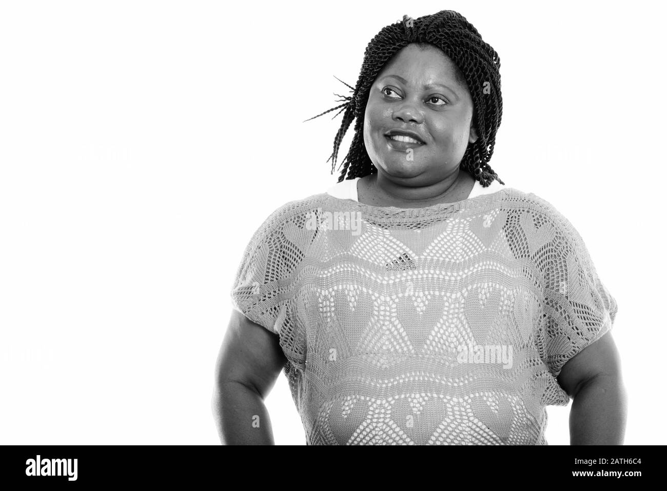 Studio tourné d'une femme africaine noire heureuse et grasse souriant tout en pensant Banque D'Images