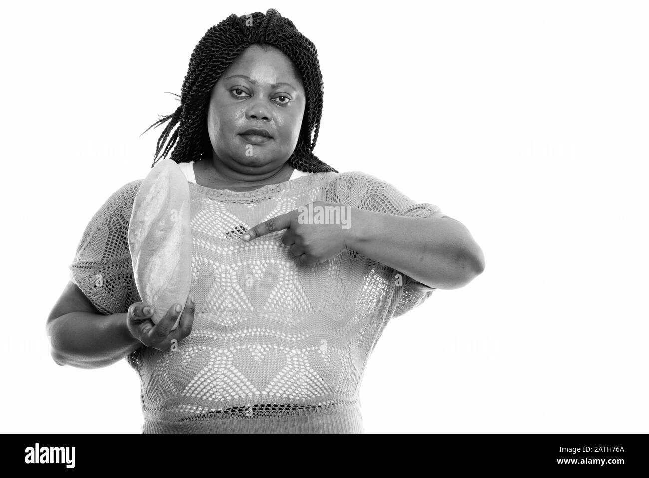 Studio tourné de graisse noire africaine femme tenant et pointant sur le pain Banque D'Images