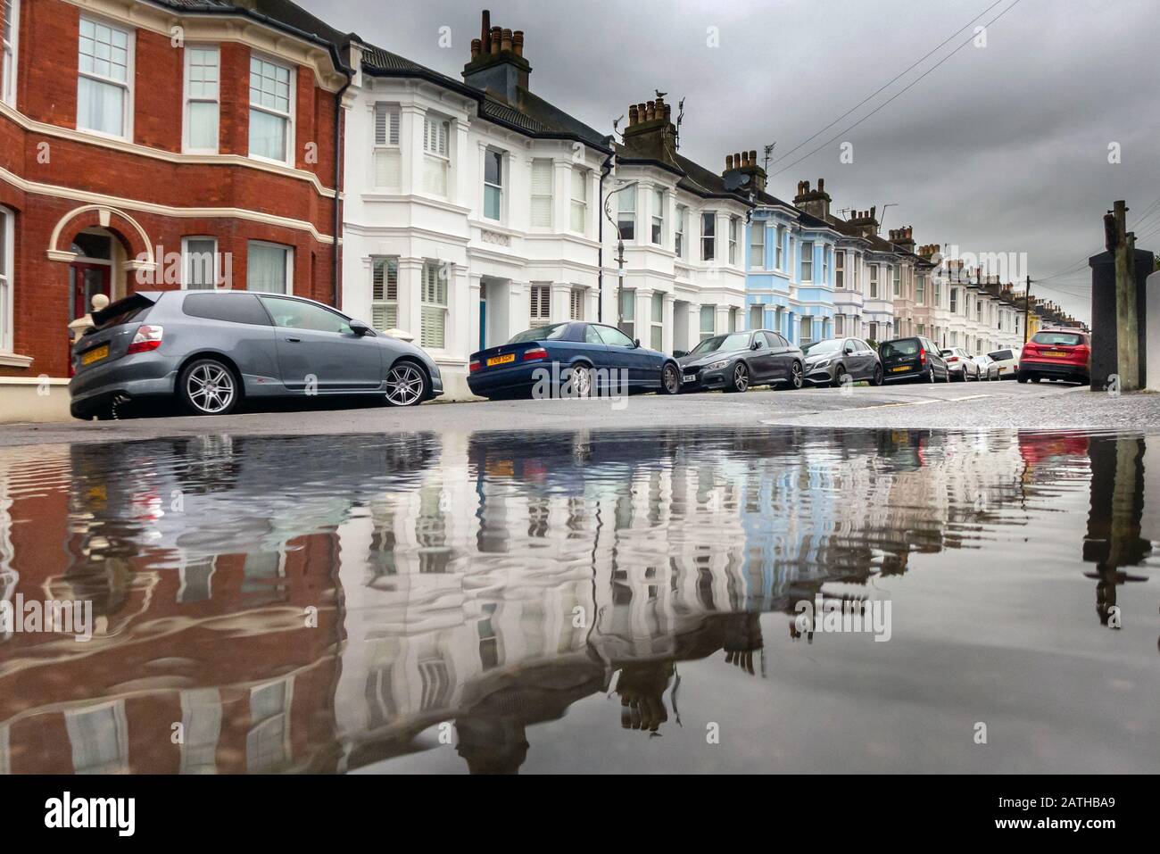 Maisons mitoyennes reflétées dans une flaque après une forte pluie Banque D'Images