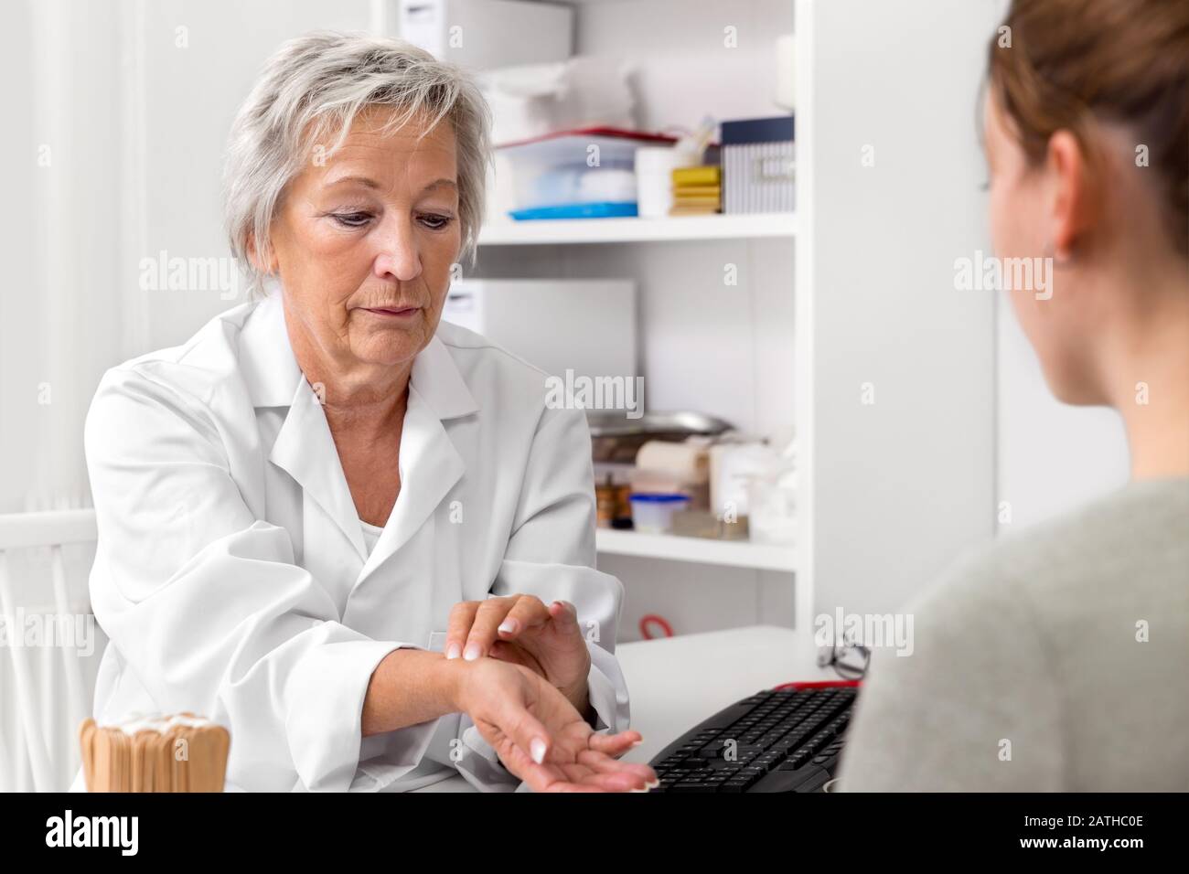 Médecin féminin montrant la fréquence cardiaque ou le pouls jusqu'à un patient, démonstration Banque D'Images