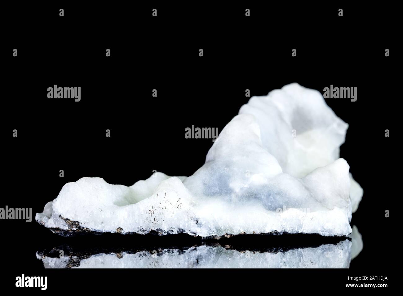 Stalactite bleue blanche ou frittée d'oxyde de calcium, pierre brute devant fond noir Banque D'Images