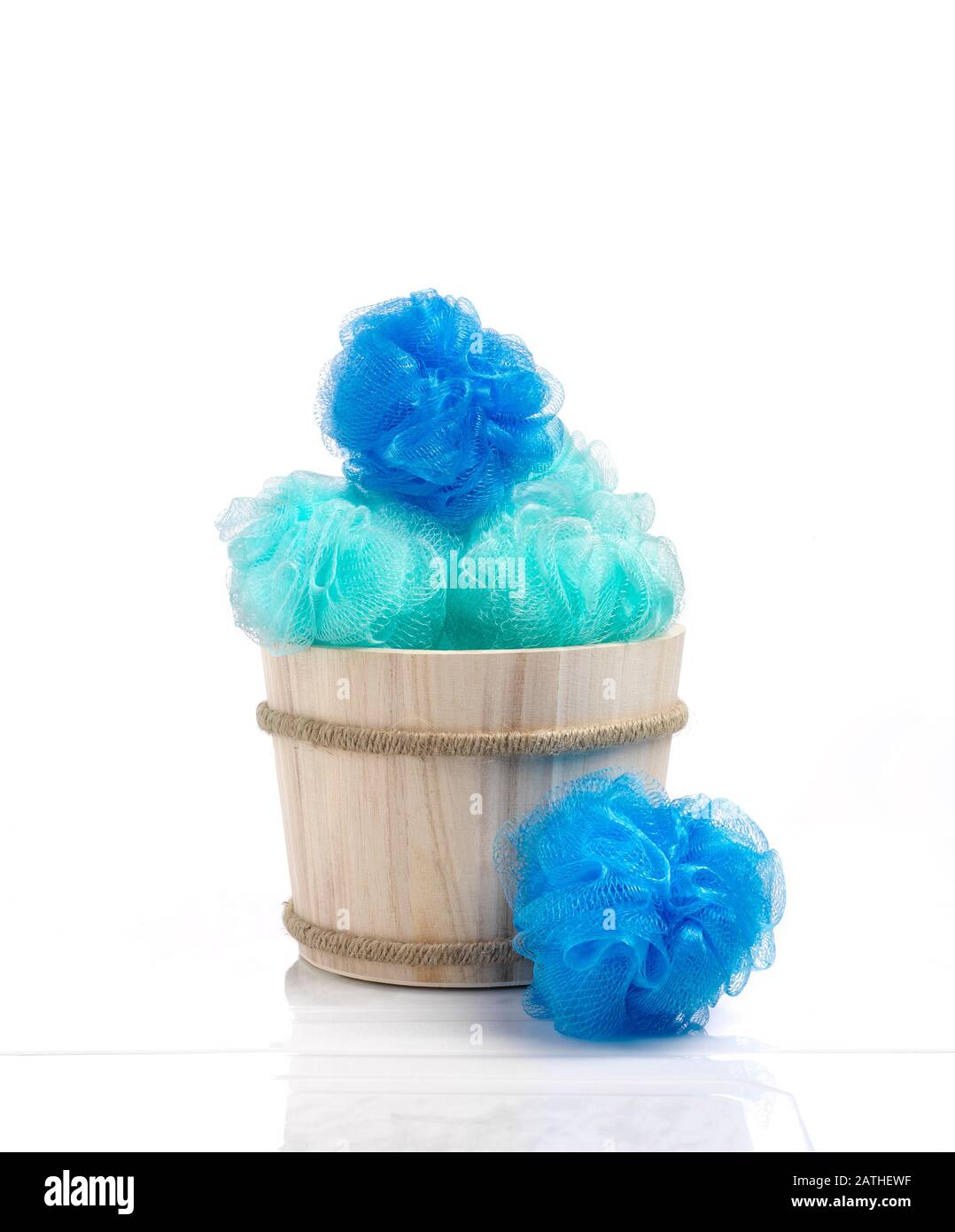 La couleur bleue s'éponge dans un panier en bois contre une ambiance de salle de bains brillante. Banque D'Images