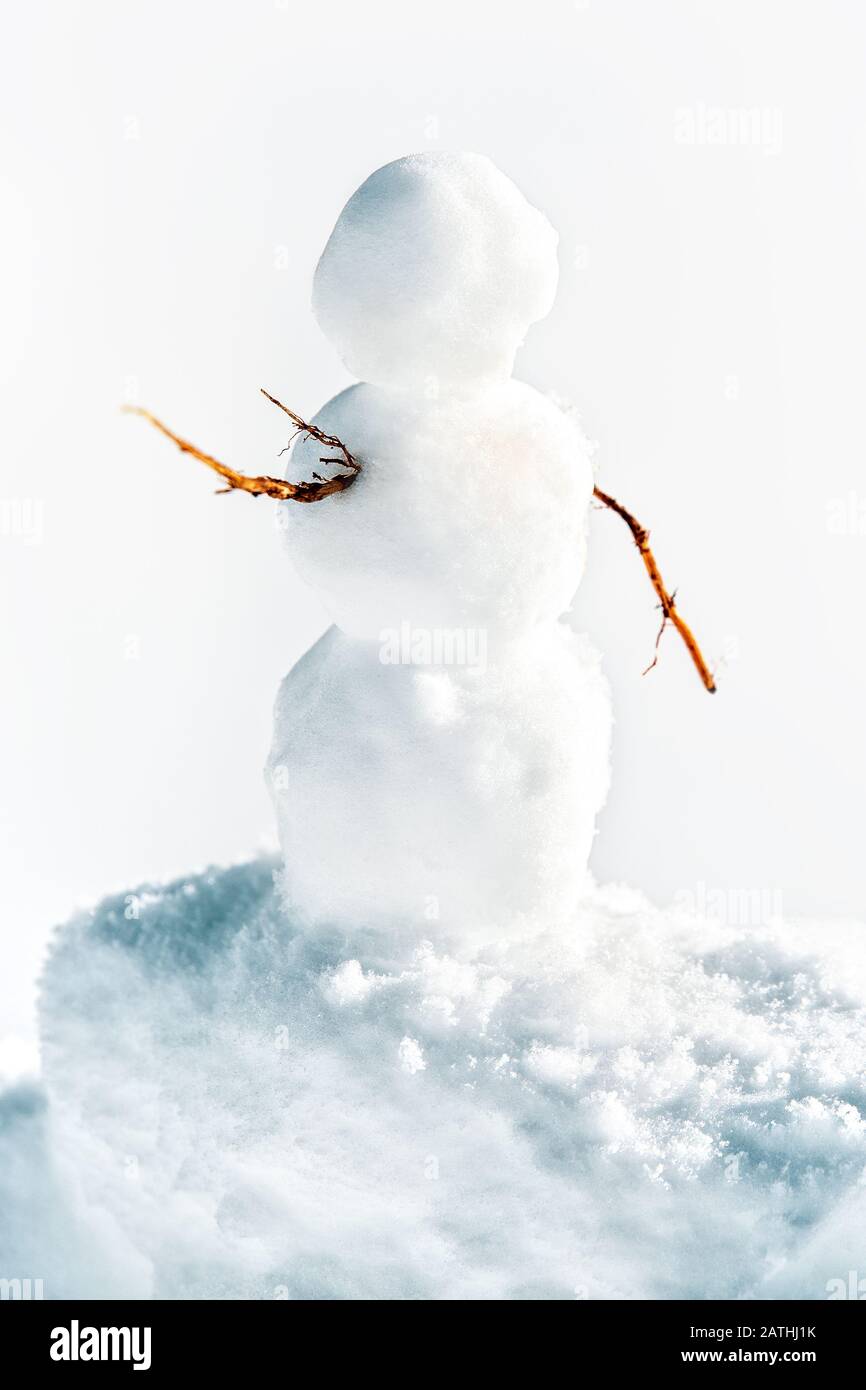 Petit bonhomme de neige mignon avec des brindilles debout dans la neige, concept hiver fond Banque D'Images
