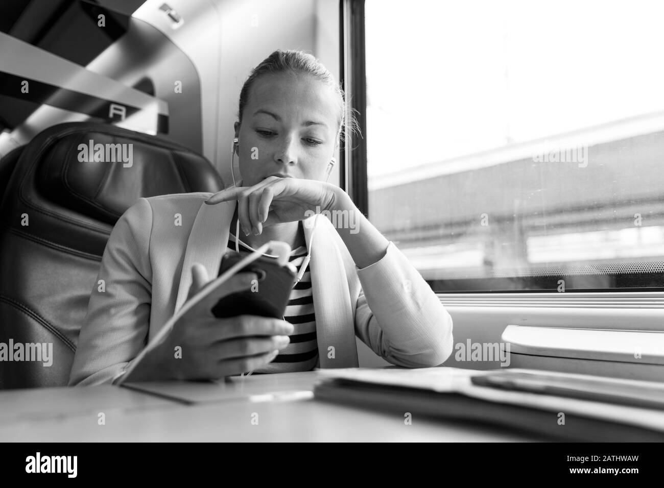Businesswoman communiquant sur téléphone portable en voyage en train. Banque D'Images