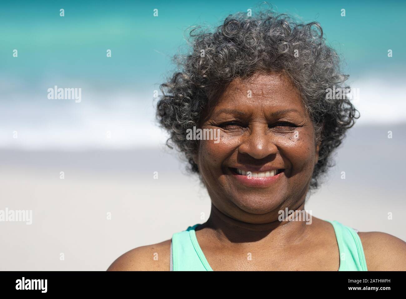 Vieille femme souriante à la plage Banque D'Images