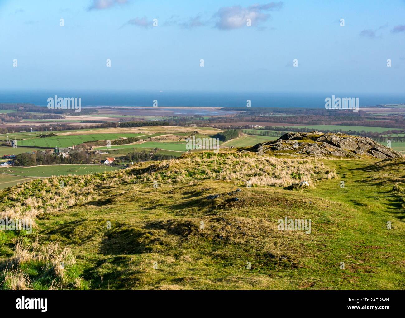 Traprain Law, East Lothian, Écosse, Royaume-Uni. 3 février 2020. Royaume-Uni Météo : une journée très venteuse sur la colline volcanique avec le soleil illuminant le paysage rural environnant. La vue vers le Firth of Forth Banque D'Images