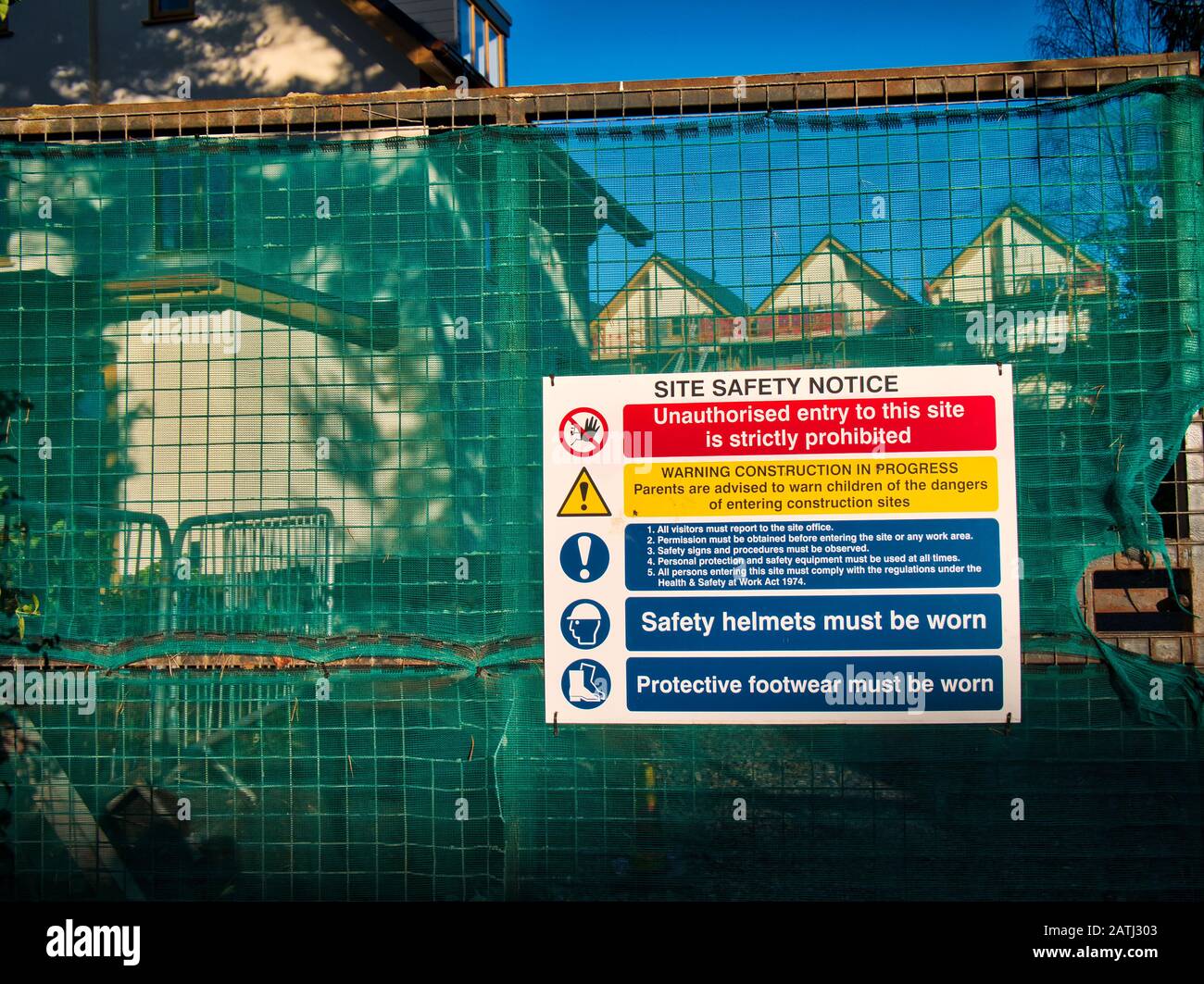 Un avis de sécurité sur les chantiers de construction et de construction aux couleurs vives à la porte fermée d'un aménagement urbain au Royaume-Uni Banque D'Images