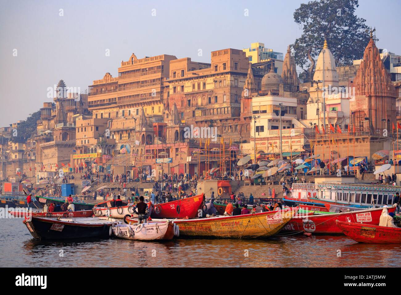 Varanasi, INDE, 18 JANVIER 2019 : Paysage de lever de soleil sur les ghats de Varanasi et les rives du Ganga avec des bateaux touristiques. Banque D'Images