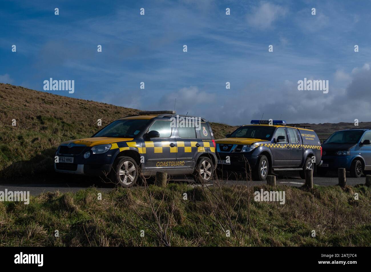 Deux véhicules tout-terrain de recherche et de sauvetage de Coastguard à damier jaune et bleu vif 4 garés au-dessus de la plage de Ggarhian au soleil et au vent Banque D'Images