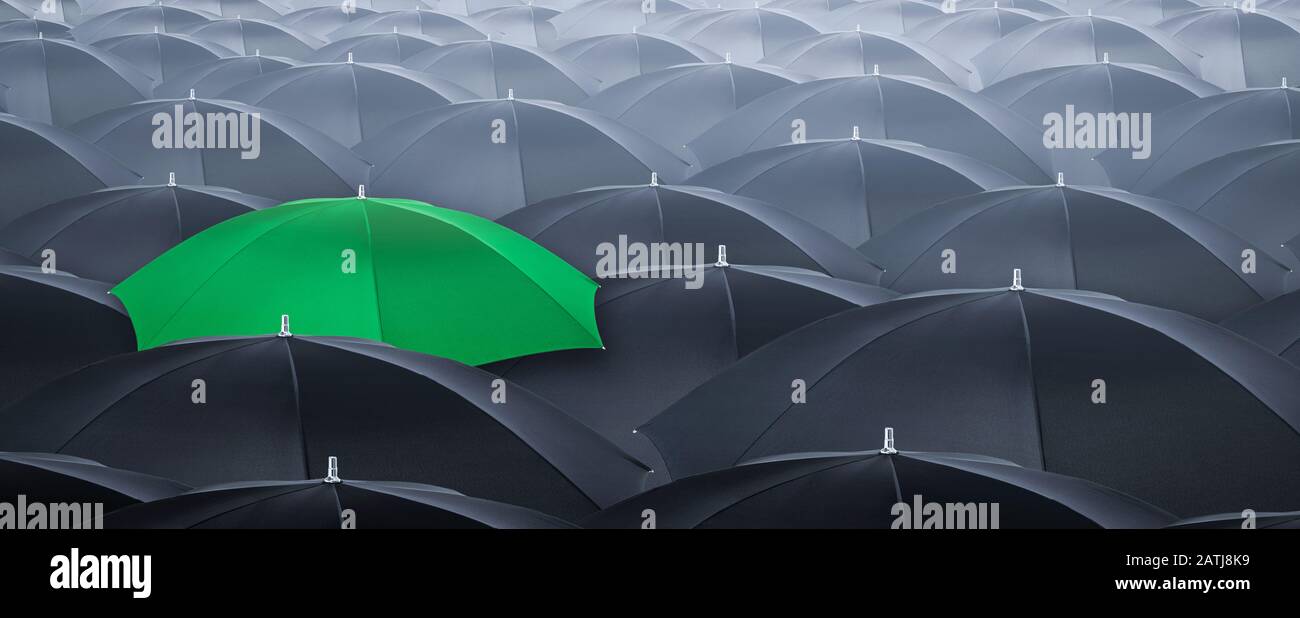Différent et se démarquer de la foule jaune parapluie. Concept de leader avec beaucoup de parapluie noir. Banque D'Images