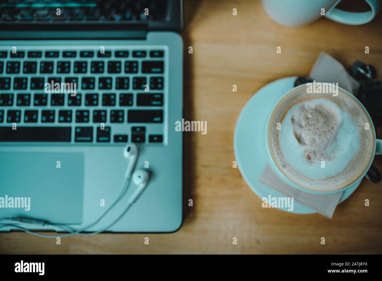 Vue sur le dessus d'un ordinateur portable et d'une tasse de cappuccino dans le studio de la maison Banque D'Images