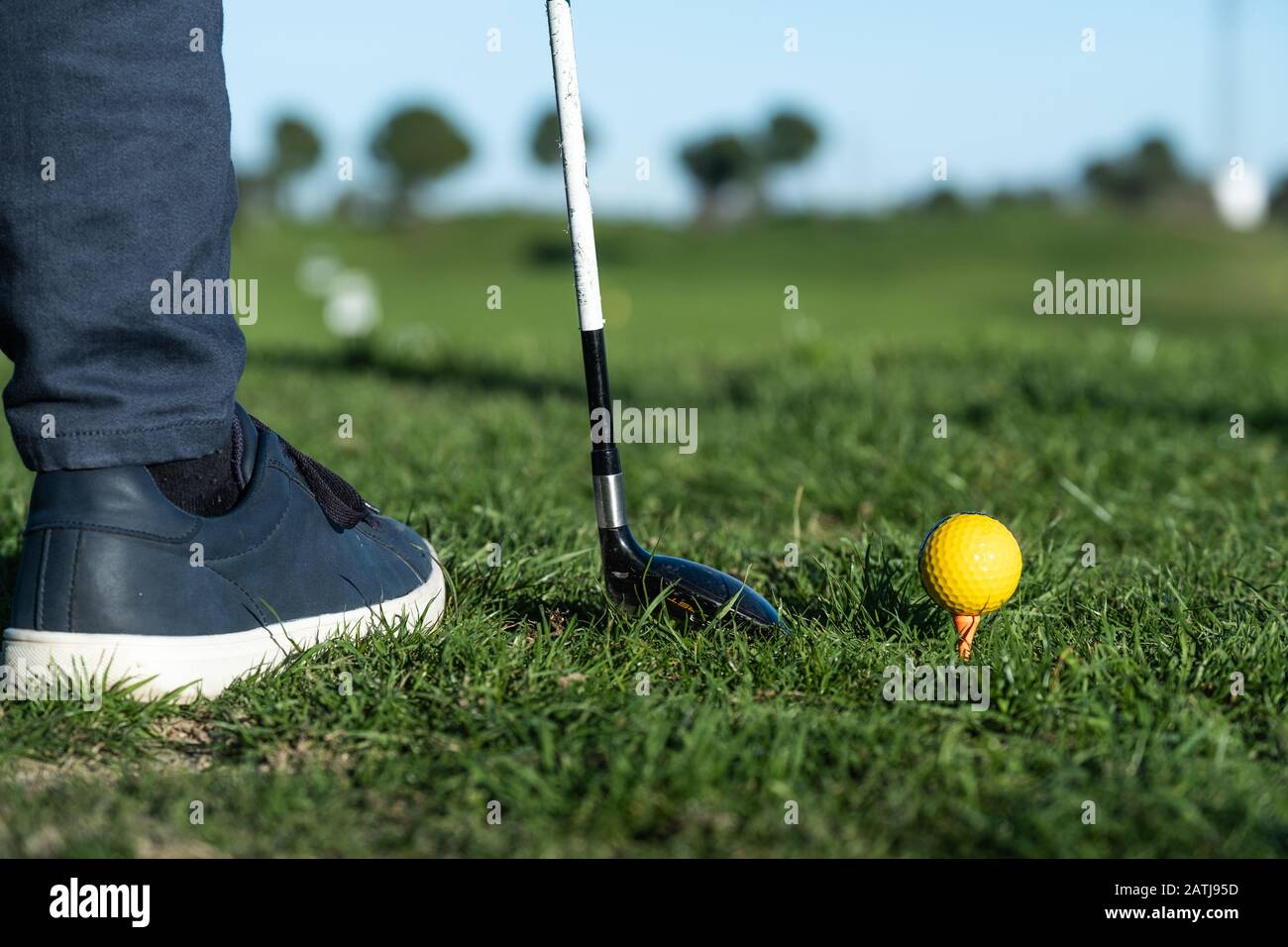 gros plan de chaussures, club de golf et ballon de golf sur un terrain d'exercice Banque D'Images