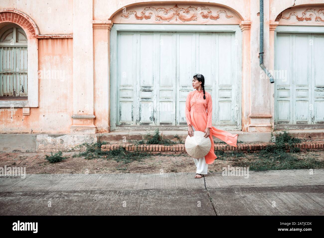 La jeune femme est gaie avec le style français historique de la maison. Dans La Province De Sakon Nakhon, Thaïlande Banque D'Images