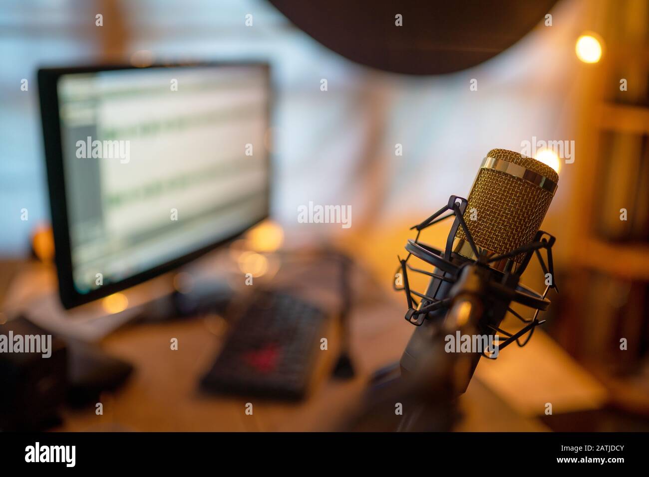 Microphone condensateur gros plan doré dans le studio d'enregistrement créant l'effet sonore pour le créateur de contenu de Vlog ou Blogger freelance Banque D'Images