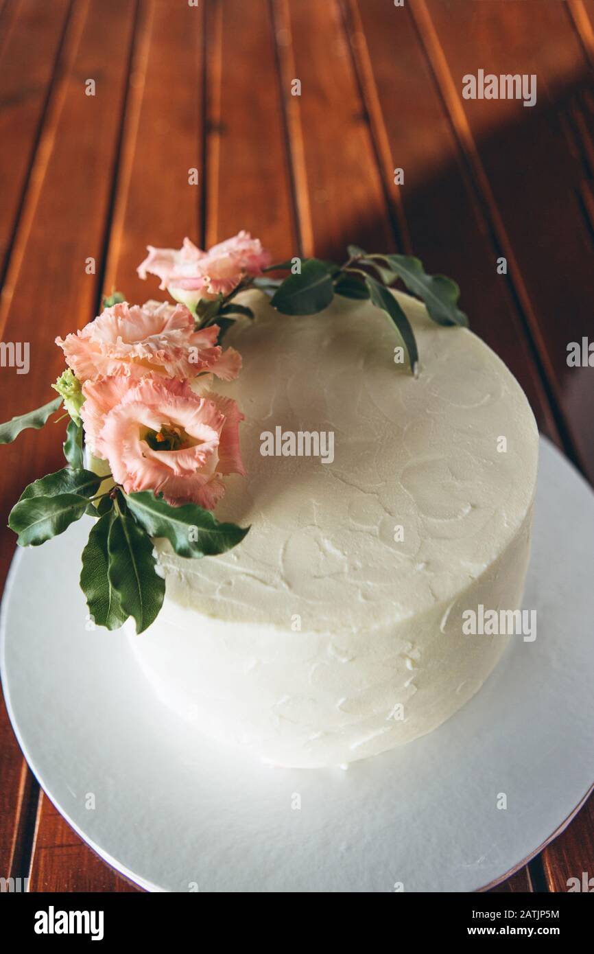 Gâteau crème savoureux décoré de fleurs sur une table en bois. Banque D'Images