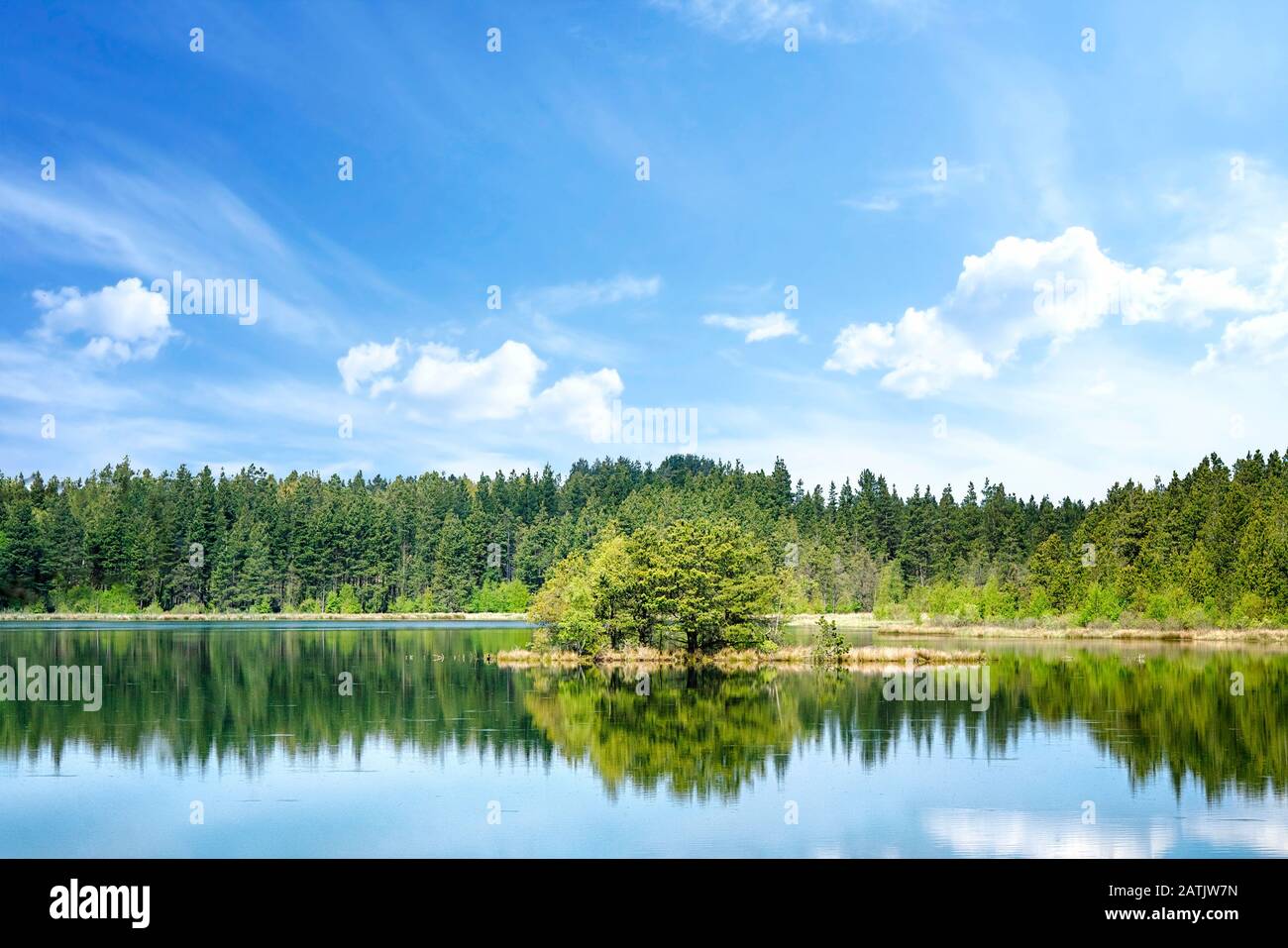 Paysage de lac coloré avec des reflets d'arbres dans l'eau et avec une petite île au milieu Banque D'Images