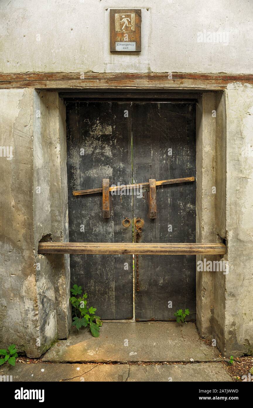 Porte fermée en bois endommagée avec texte de sortie d'urgence en anglais  et chinois Photo Stock - Alamy