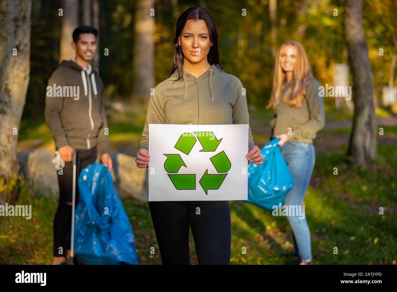Une femme volontaire confiante portant un étiquette de symbole de recyclage Banque D'Images