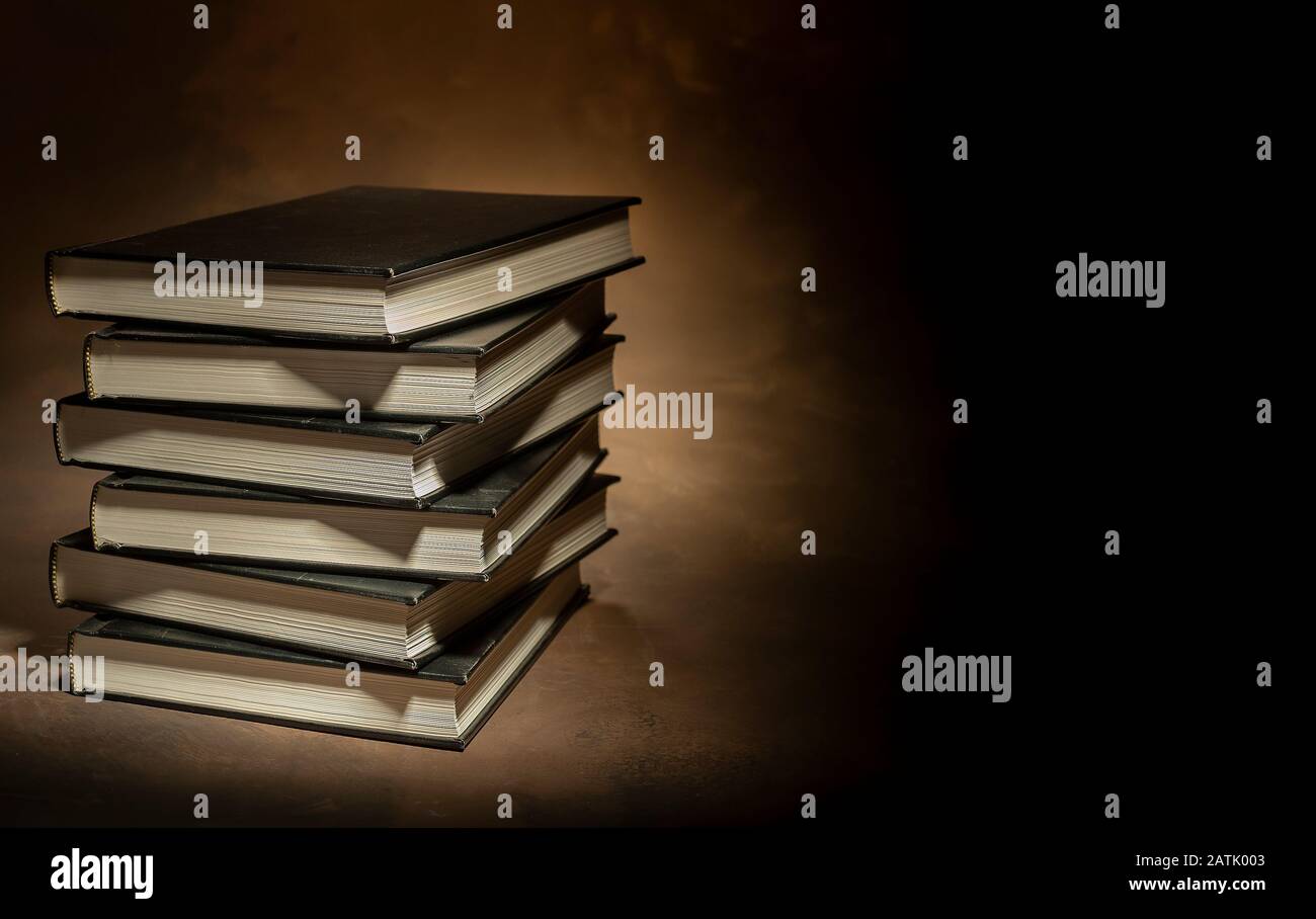 Pile de livres de couverture rigide sur fond brun, espace pour le texte à droite Banque D'Images