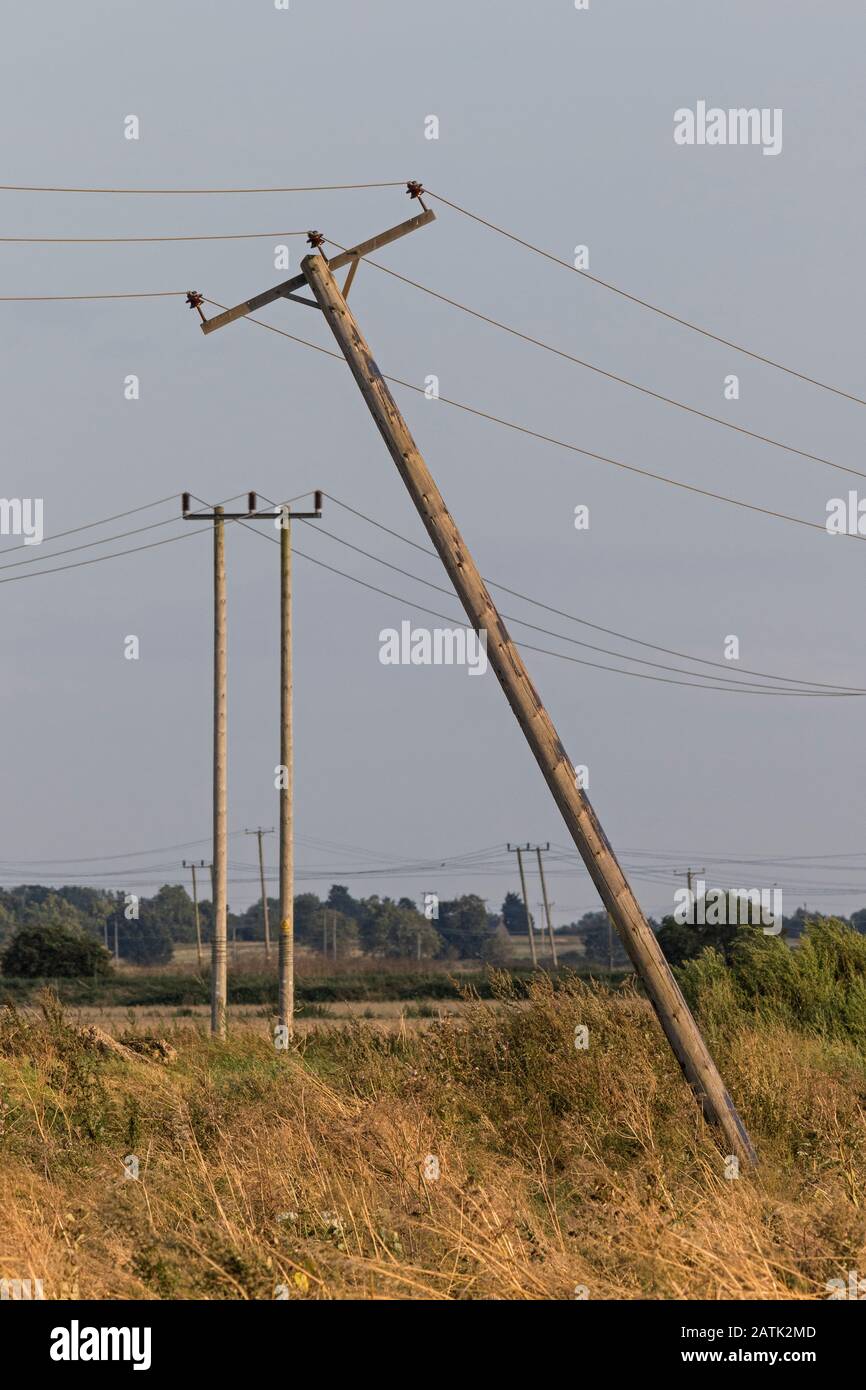 Poteaux de télégraphe penchant, dans les Fens, près de Haddenham, Cambridgeshire, Angleterre Banque D'Images
