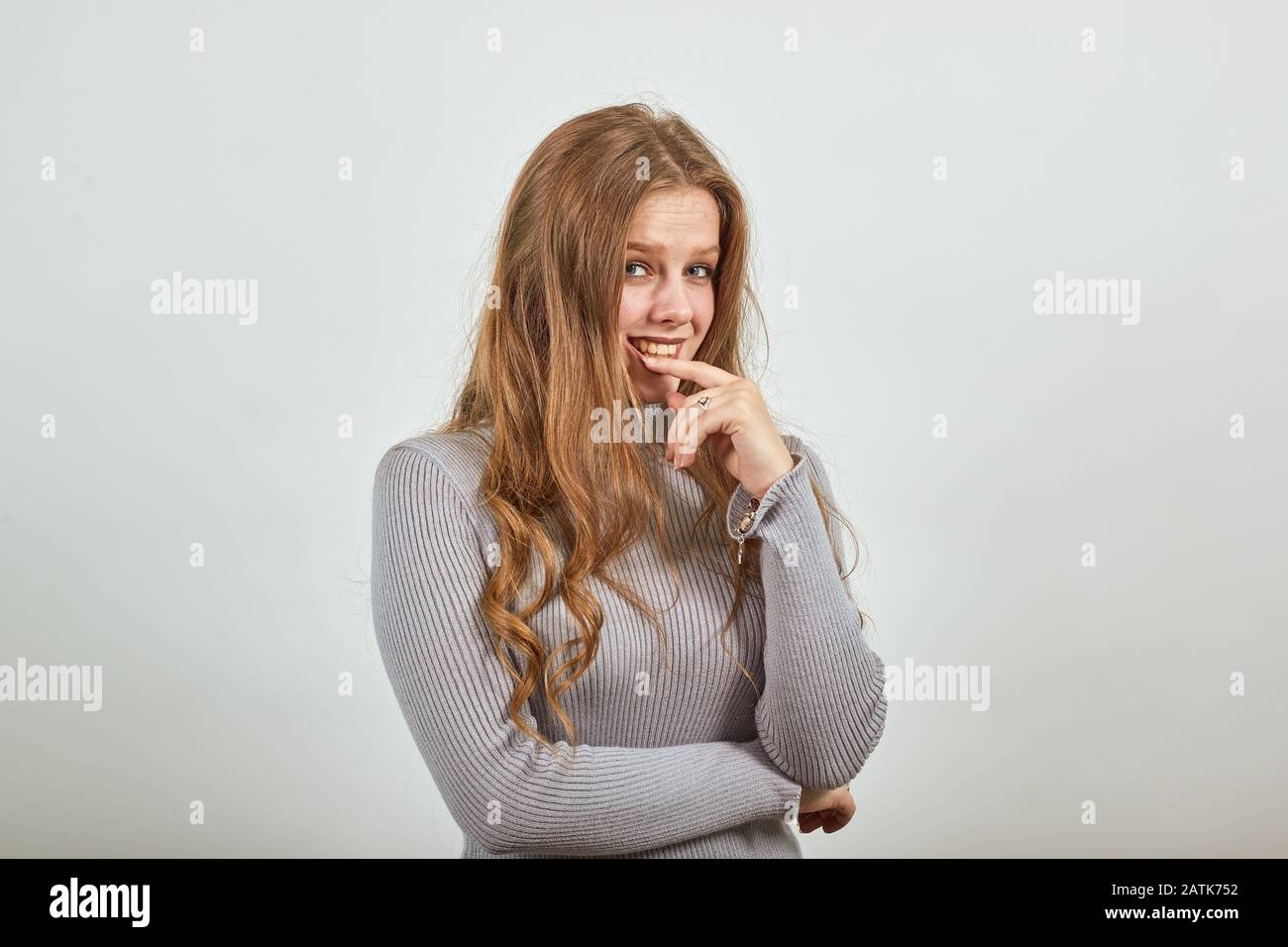 une jeune belle femme à poil rouge dans le sweat gris heureux de bonne  humeur pense Photo Stock - Alamy