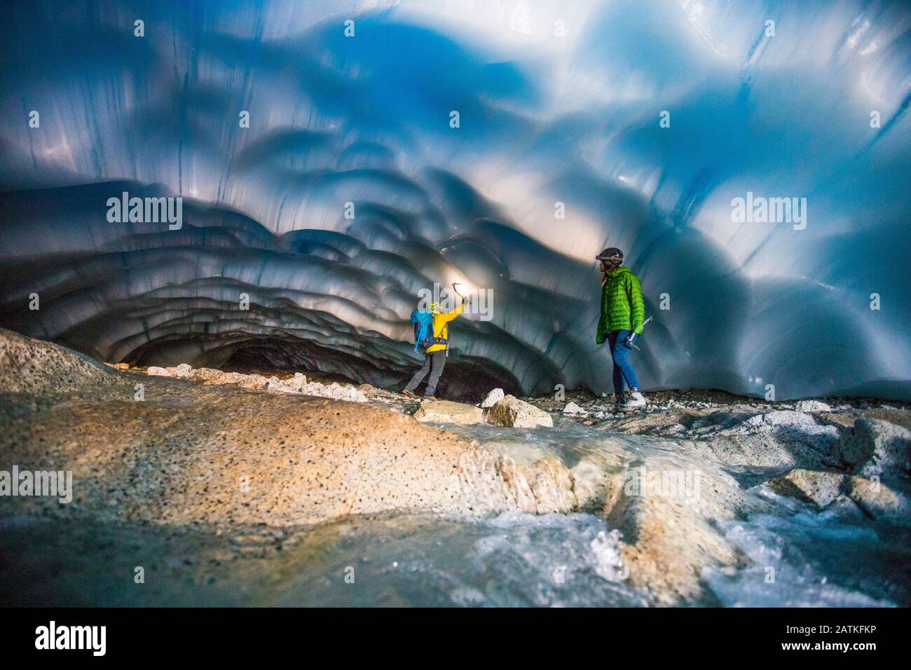 Couple aventureux explorant une grotte de glace. Banque D'Images
