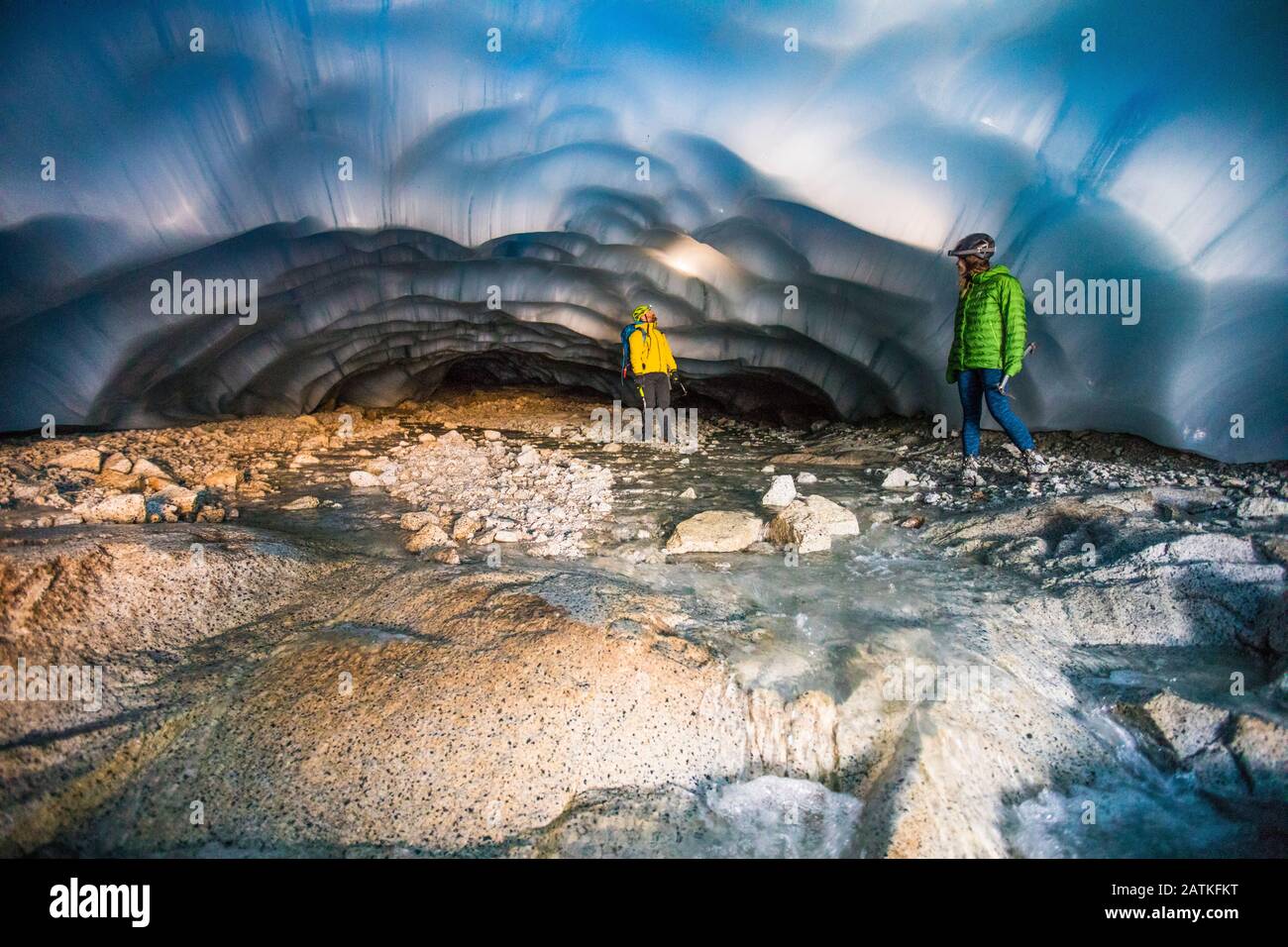 Couple aventureux explorant une grotte de glace. Banque D'Images