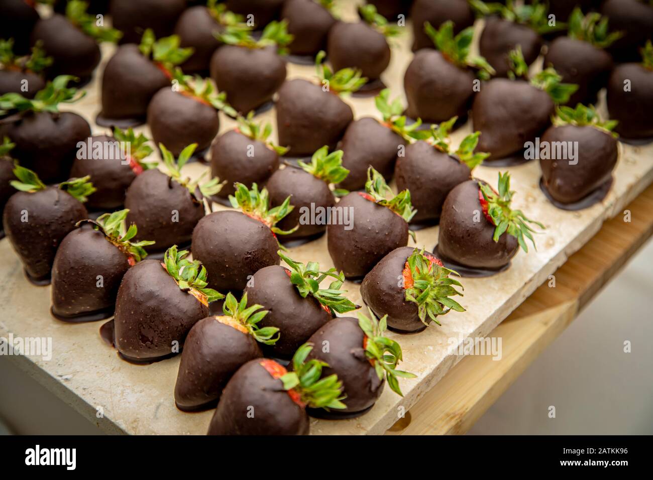 Grand groupe de fraises enrobées de chocolat noir à la fête Banque D'Images