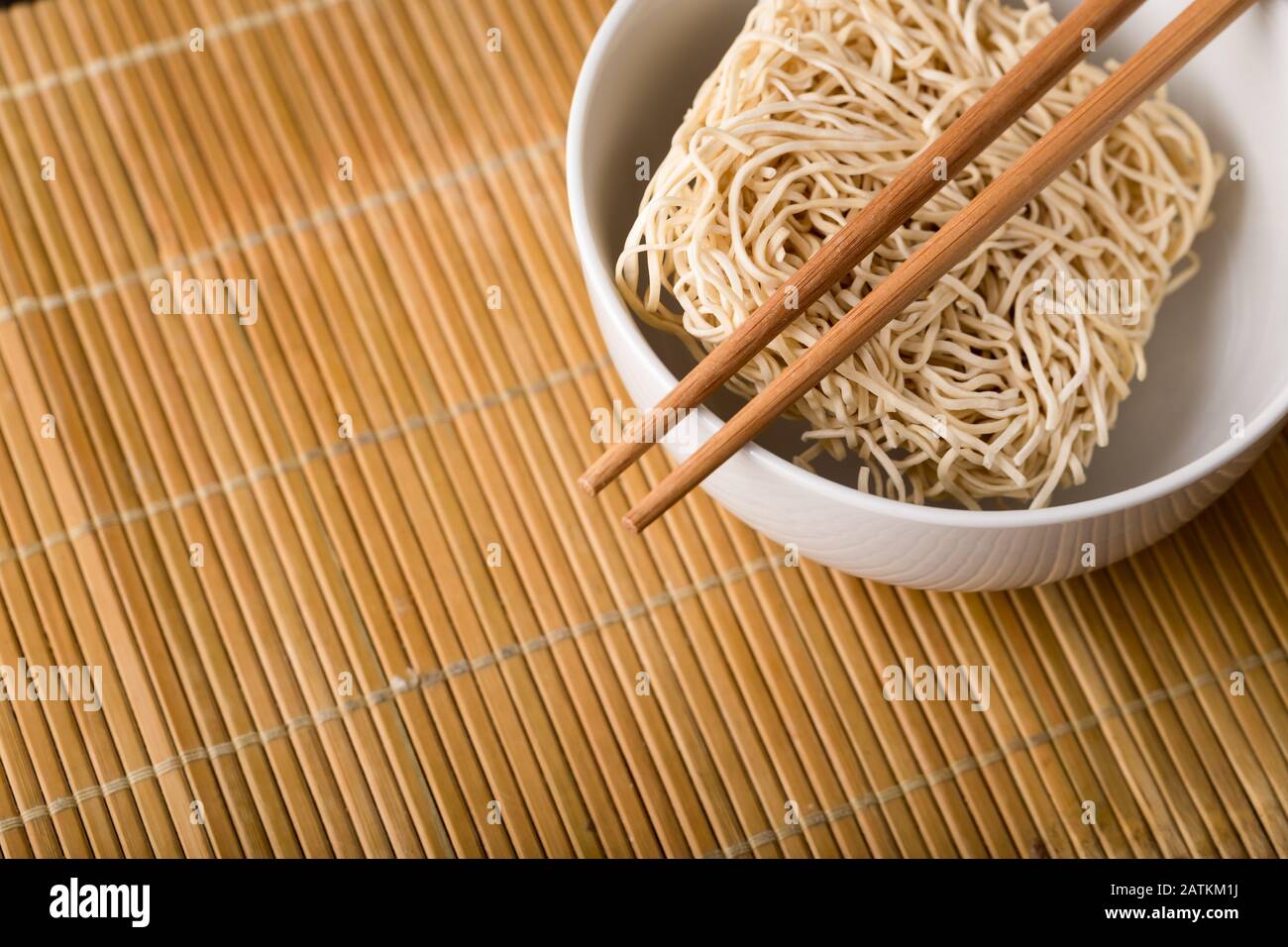 Nouilles chinoises séchées dans un bol. Bâtonnets de bambou. Cuisine asiatique. Banque D'Images
