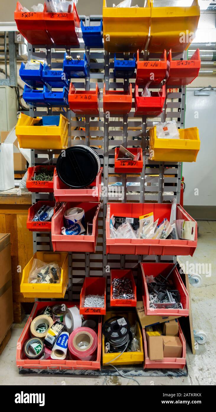 Ancien système de rack de pièces de rechange mal rangé et désordonné dans un atelier d'ingénieurs de maintenance Banque D'Images