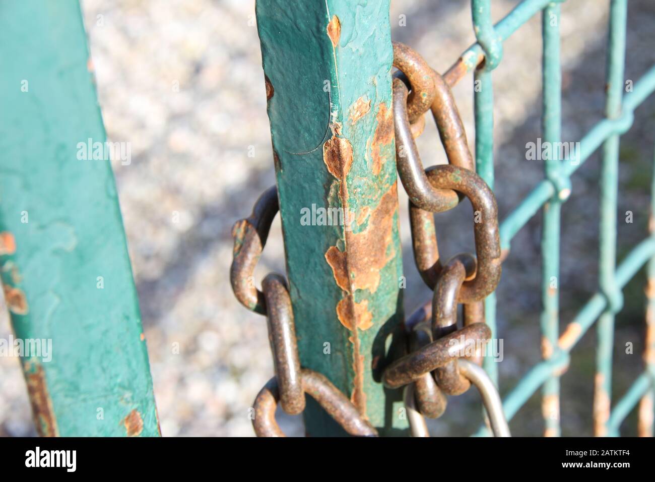 La chaîne avec un cadenas verrouille la porte métallique rouillée. Banque D'Images