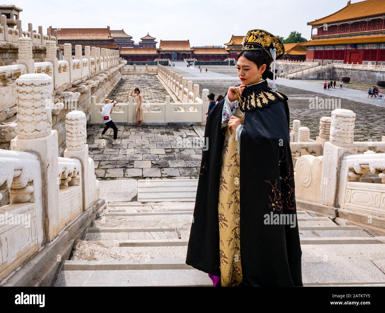 Femme portant un costume royal chinois de la période avec touriste prenant une photo, Cour extérieure, Cité Interdite, Beijing, Chine, Asie Banque D'Images