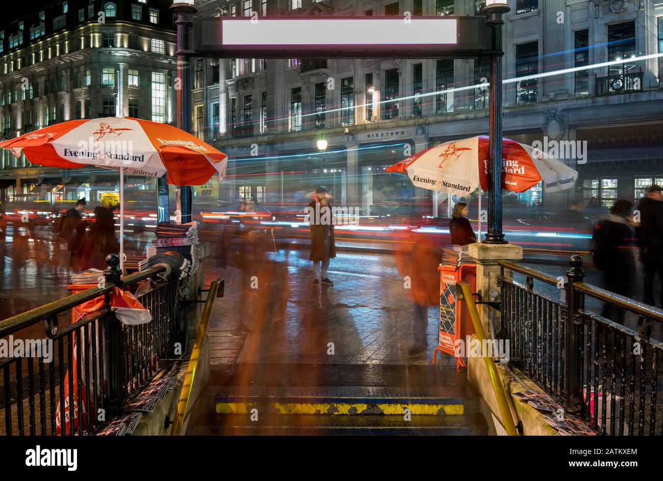 Gare d'Oxford Circus pendant les heures de pointe la nuit. Photo d'exposition longue montrant le mouvement des personnes et de la circulation. Banque D'Images