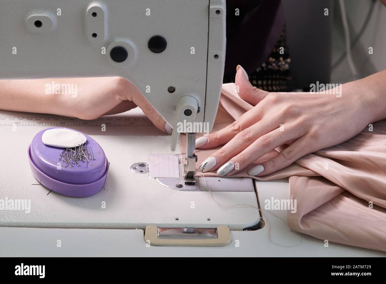 Femme utilisant une machine à coudre dans un atelier sur mesure ou un atelier d'atelier moderne Banque D'Images