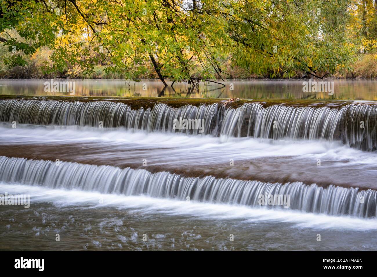 Eau en cascade au-dessus d'un barrage de dérivation sur la rivière Poudre avec des couleurs d'automne en arrière-plan, nature et concept industriel Banque D'Images
