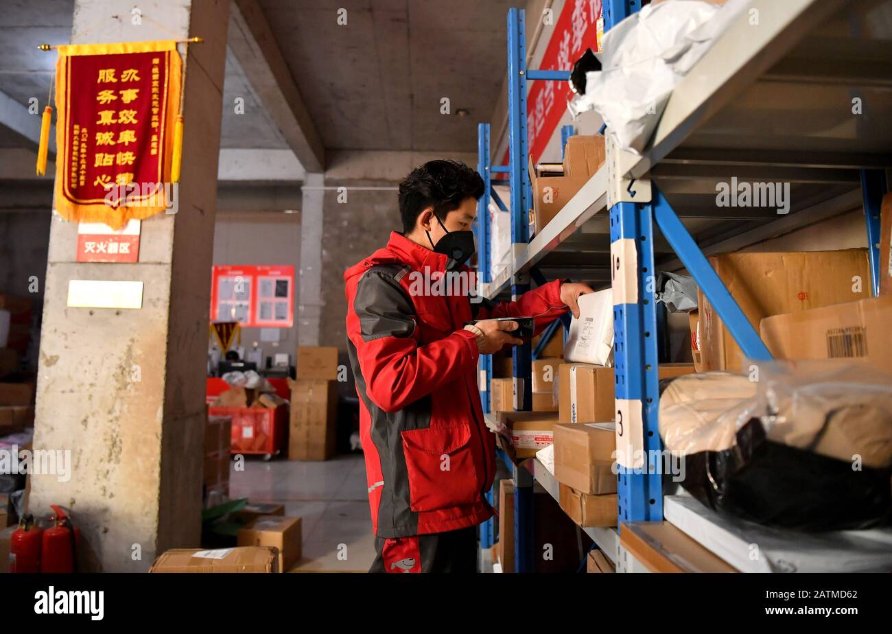 (200204) -- XI'AN, 4 février 2020 (Xinhua) -- Xu Guobin chèques paquets à Xi'an, dans le nord-ouest de la province de Shaanxi en Chine, 3 février 2020. Le livreur Xu Guobin a continué à travailler pendant les vacances du Festival du printemps pendant 12 jours. Influencé par le déclenchement de nouveaux coronavirus, Xu doit livrer des colis trois fois plus que les dernières années. Lorsqu'on lui a demandé s'il s'inquiétait d'être infecté, Xu a répondu en disant que bien qu'il ait eu une telle préoccupation, ce qu'il pouvait faire était de bien se protéger tout en livrant des colis aux personnes qui en avaient besoin. (Xinhua/Liu Xiao) Banque D'Images