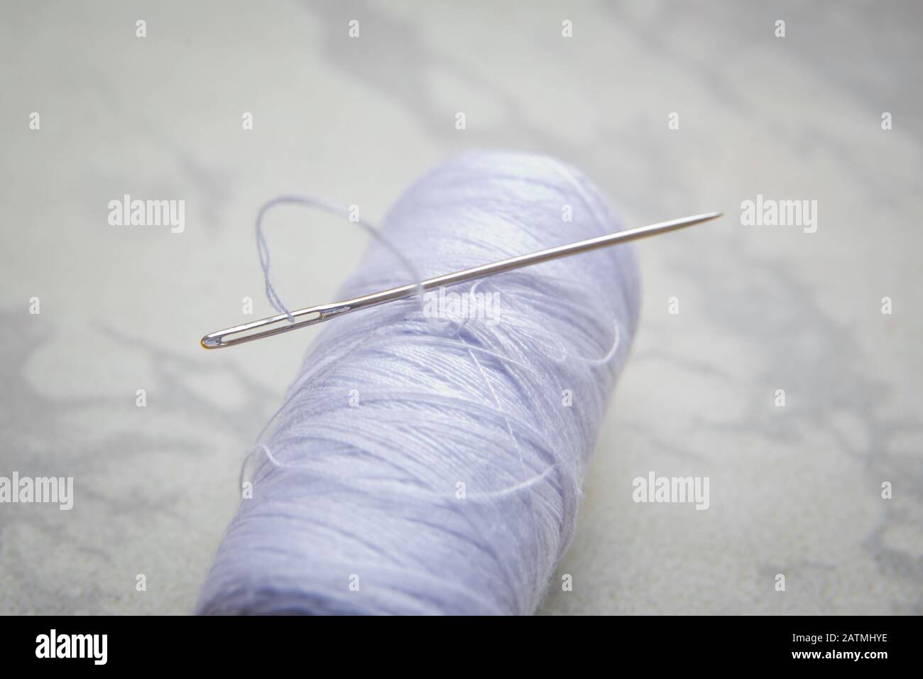 Bobine blanche avec aiguille isolée sur blanc .gros-plan de fil à coudre avec aiguille à broder. Métiers d'art et concepts de bricolage . Aiguille sur filetage blanc blanc Banque D'Images