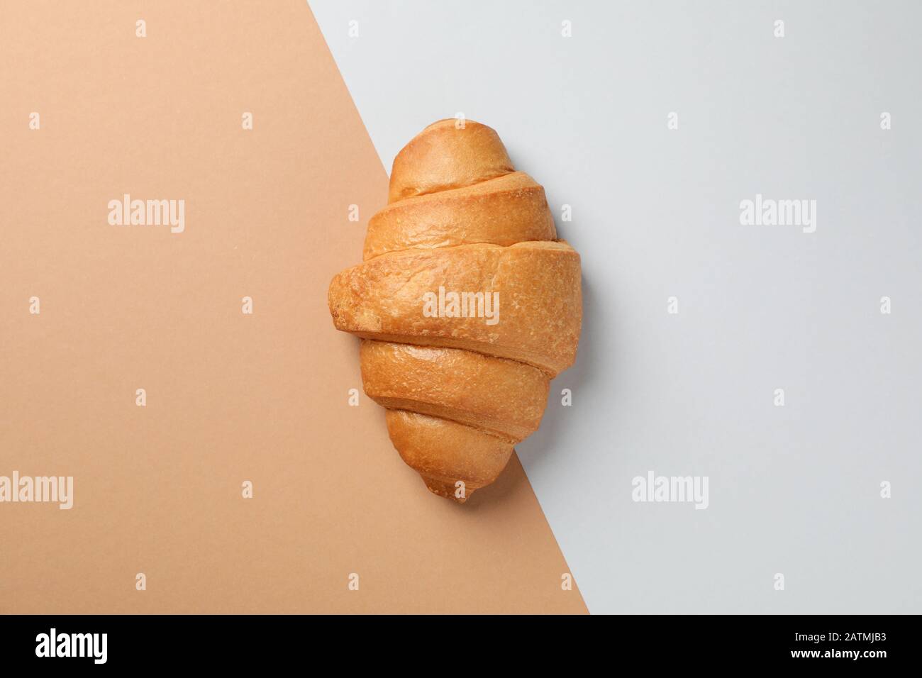 Croissant fraîchement cuit sur fond à deux tons, vue sur le dessus Banque D'Images