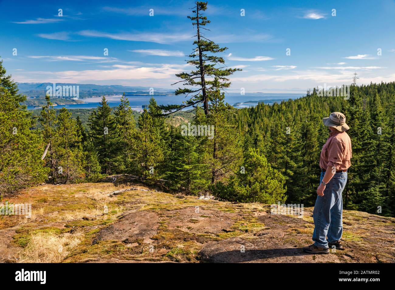 Randonneur senior regardant les îles Discovery, point de vue sur Le lac Little Nugedzi, île Quadra, Colombie-Britannique, Canada Banque D'Images