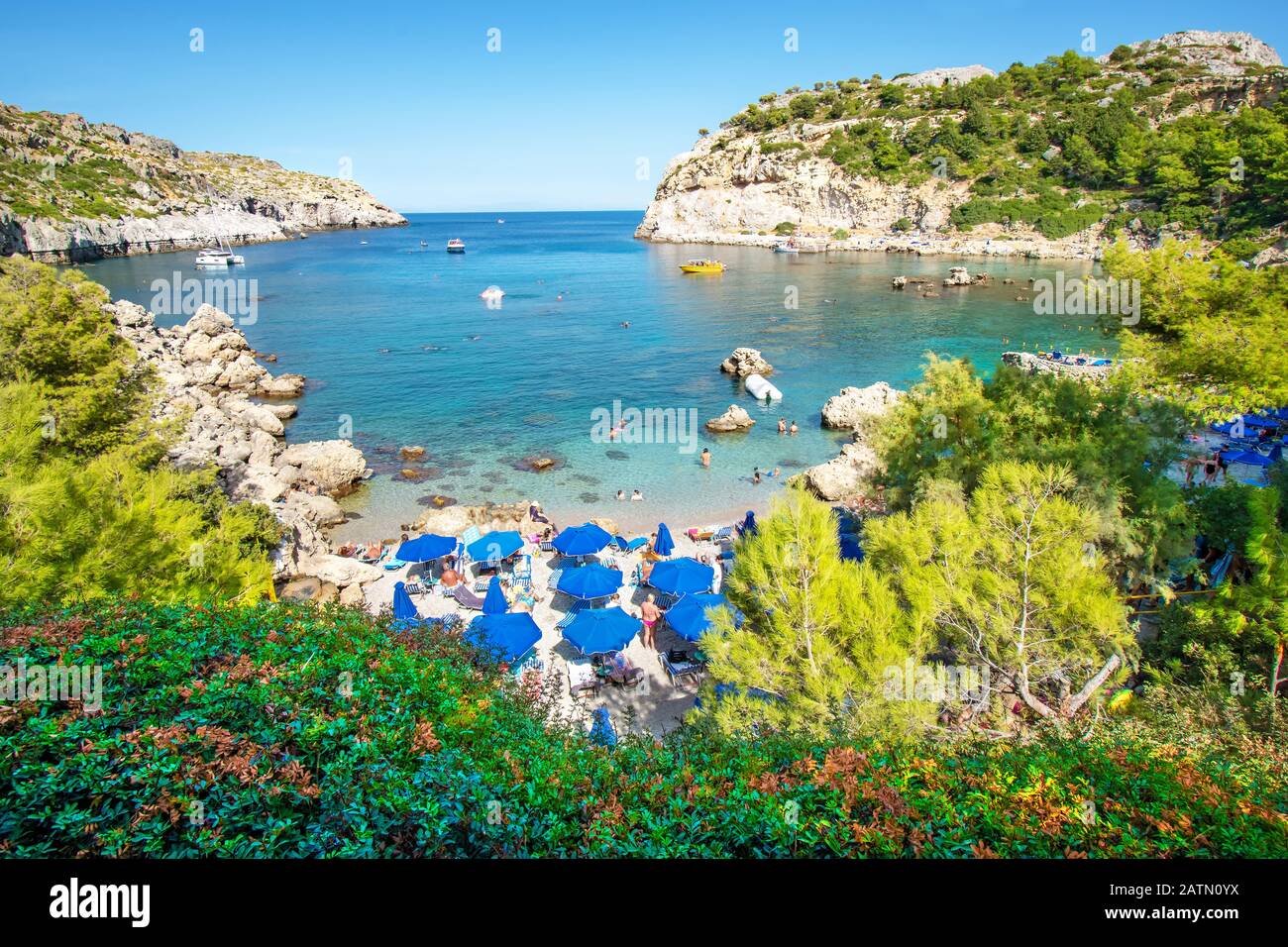 Petite plage avec touristes, parasols et chaises longues dans la baie Anthony Quinn (Rhodes, Grèce) Banque D'Images