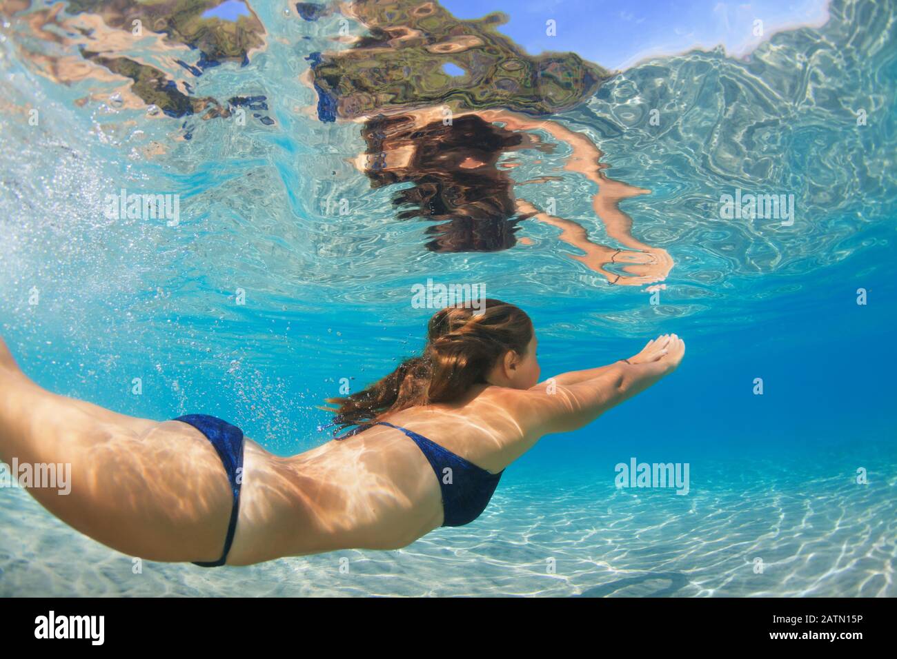 Active jeune femme plongée, nager sous l'eau pour voir les poissons tropicaux dans la piscine lagon de mer. Activité de natation, sports nautiques sur la plage d'été croisière avec les enfants Banque D'Images