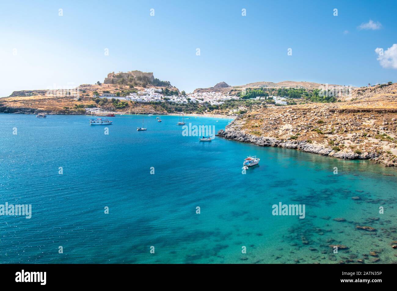 Bateaux ancrés sur la mer près du village de Lindos, Acropole de Lindos en arrière-plan (Rhodes, Grèce) Banque D'Images