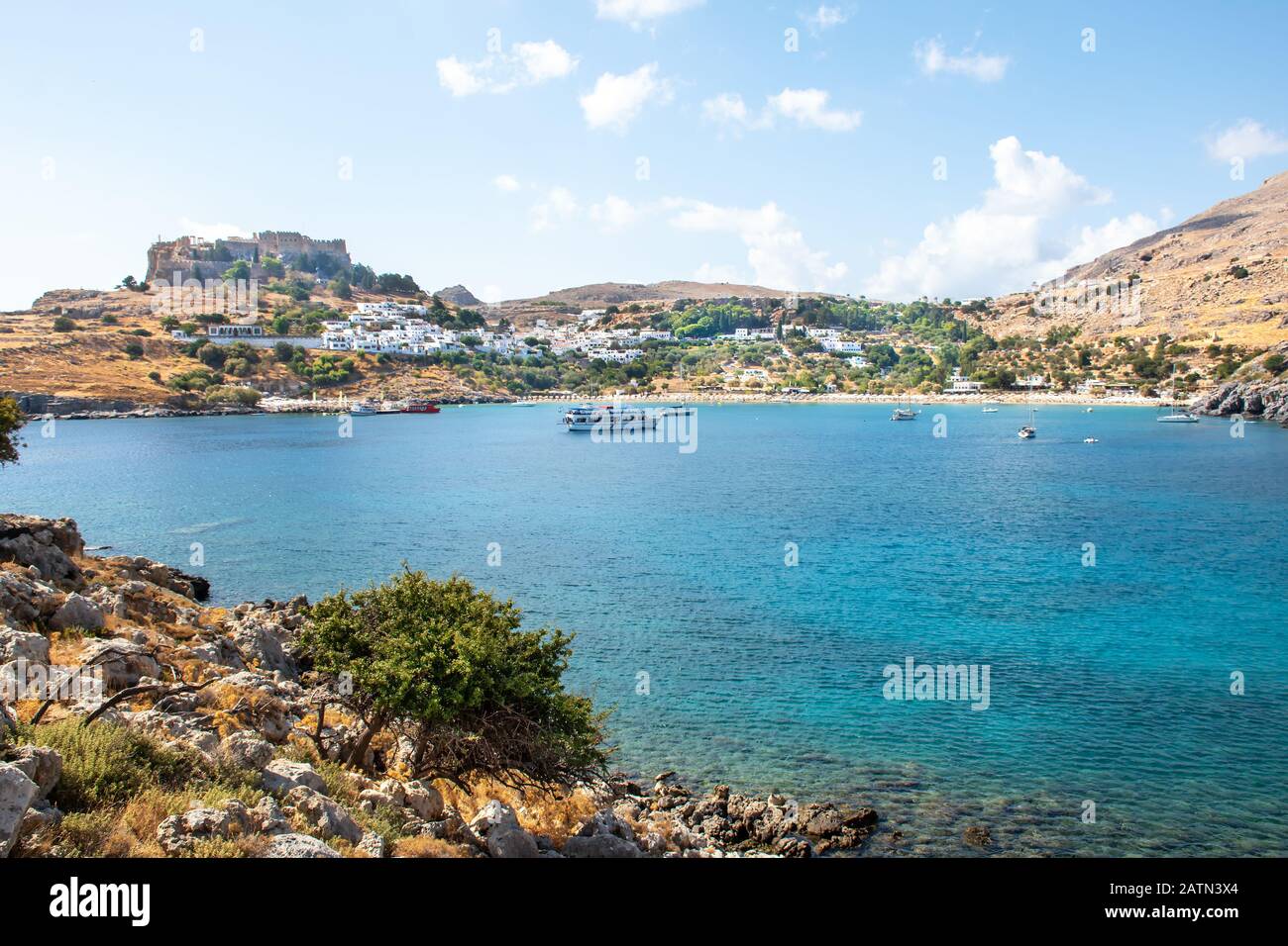 Baie de Lindos avec bateaux, maisons blanches du village de Lindos et Acropole en arrière-plan (Rhodes, Grèce) Banque D'Images