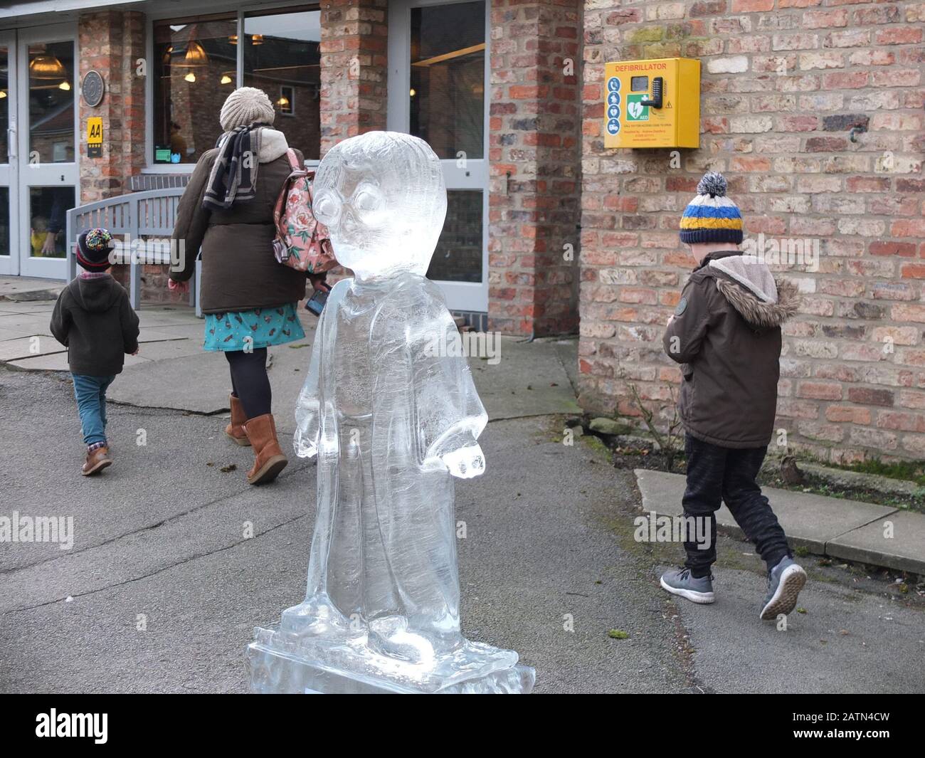 Deux jeunes garçons avec leur mère marchent au-delà d'une glace Sculpture de Harry Potter au York Ice Trail 2020 où des sculptures de glace sont exposées autour de la ville Banque D'Images