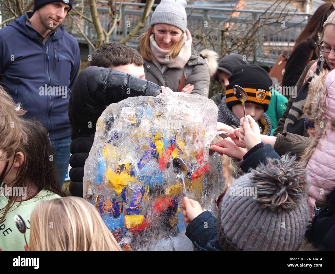 Les enfants hack déterminé à une sculpture sur glace contenant des bonbons et chocolats qu'ils peuvent manger s'ils les libèrent à York Ice Trail 2020 Banque D'Images